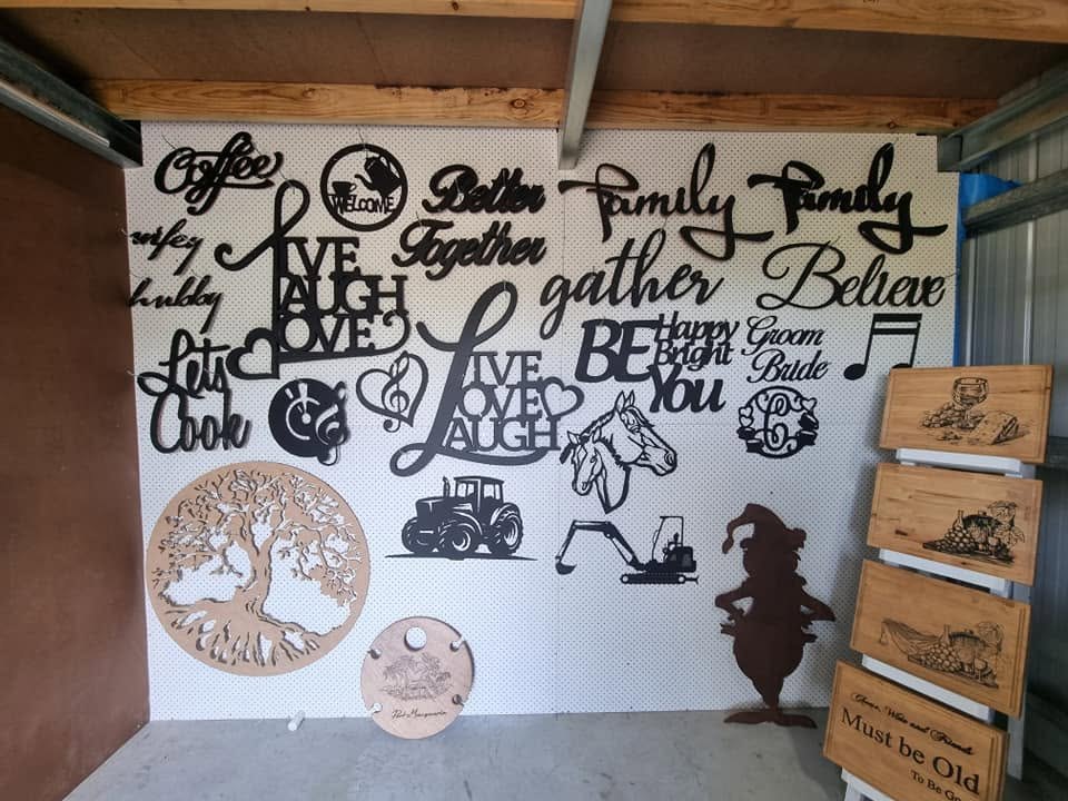 Custom laser cut lettering and timber designs displayed in the workshop
